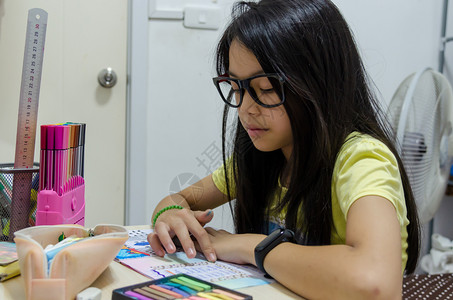 亚裔小女孩在家做庭功课学生童年读图片