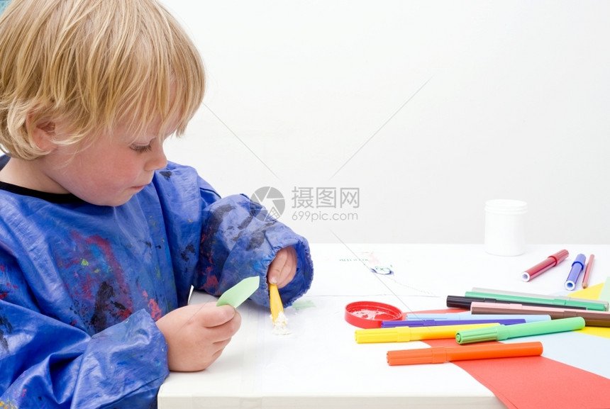 胶水单身的白种人年轻男孩在一张桌子上纸图片