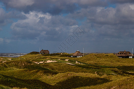 丹麦沙丘之间云的层堆积恢复海岸高清图片