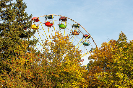 十月绿色圆形的秋天公园雪车轮蓝色天空和树木黄色叶子在城市中秋天图片