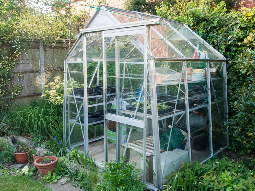 自然英国花园中典型的家用铝温室生长中央图片