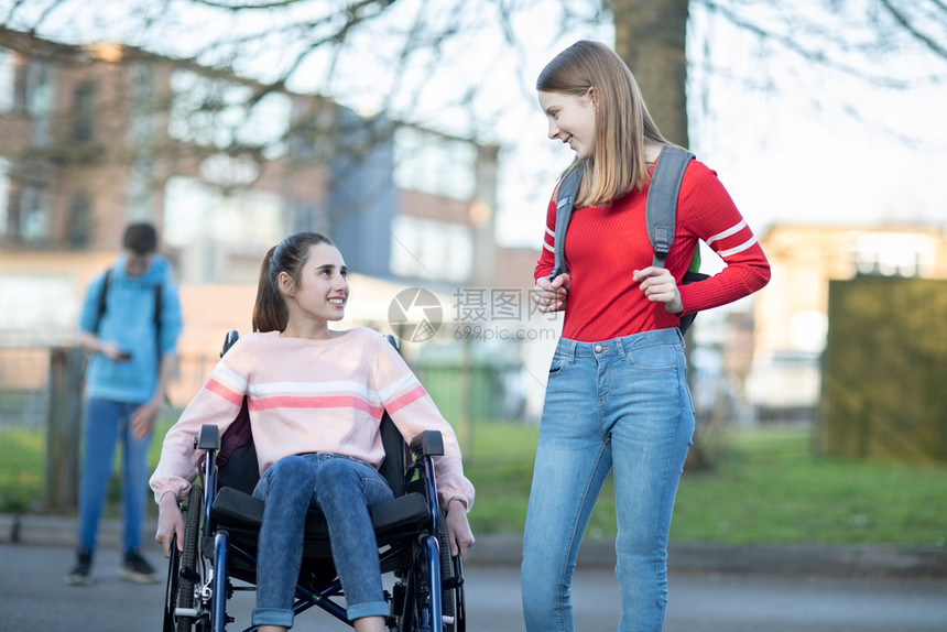 减值出去聊天在离开高中时和朋友交谈的轮椅女青少年孩在离开高中时与朋友交谈图片
