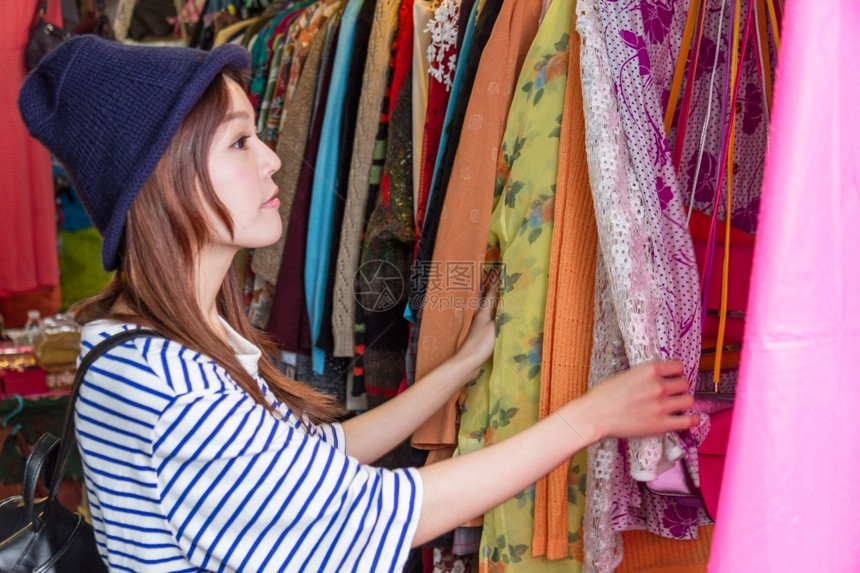 镜子购物狂时尚在台北街头市场妇女透过手袋在架子上寻找图片