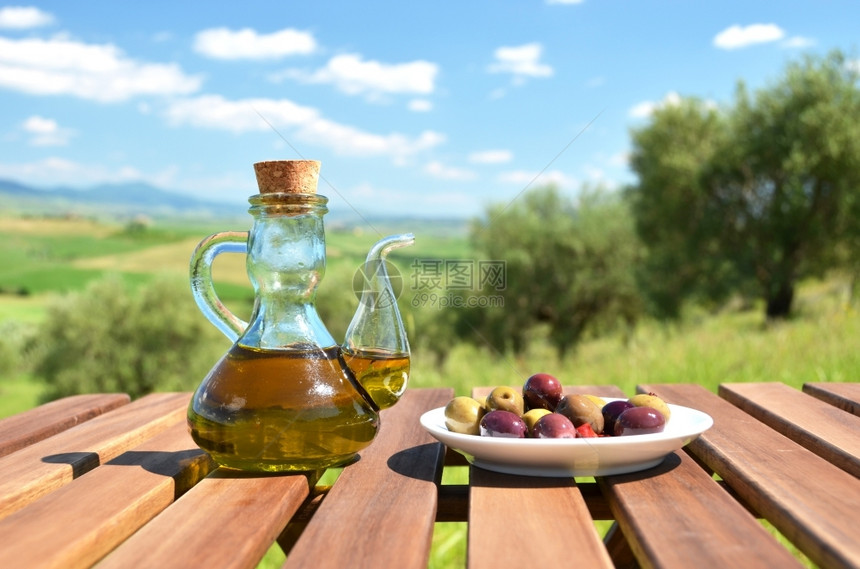 木制桌上的橄榄油和意大利图斯卡风景树林乡村的托斯卡纳图片