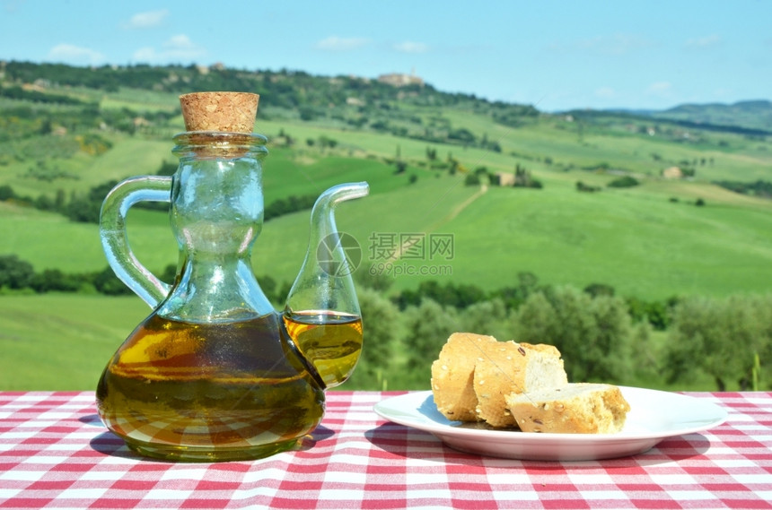 锡耶纳食物用橄榄油和面包对抗意大利的托斯卡纳风景瓶子图片