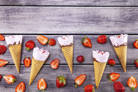 成熟甜点木头冰淇淋和草莓的锥子在古老的木制桌边上夏季关注冰淇淋图片