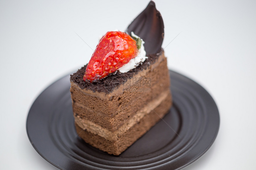 新鲜的桌子复制空间巧克力蛋糕的切片和白桌上黑沙盘中的草莓图片