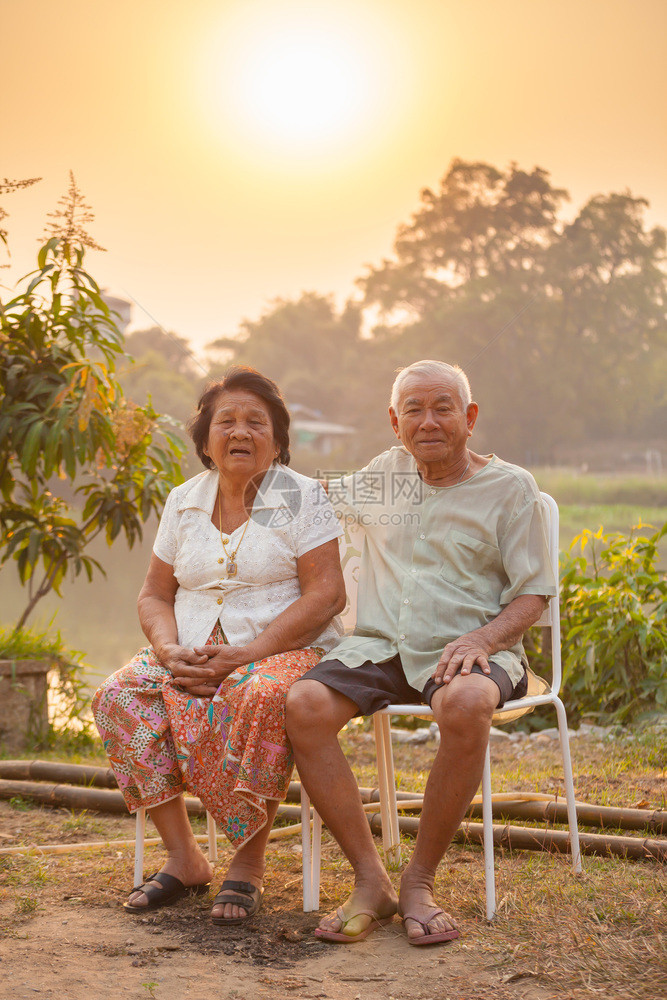 乐趣成人白色的日落时坐在户外的亚洲幸福老年情侣图片