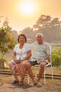 乐趣成人白色的日落时坐在户外的亚洲幸福老年情侣背景图片