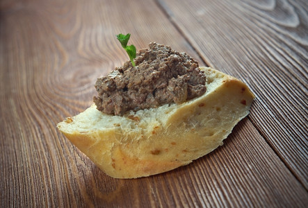 小吃猪肉鸡肝酱和木制餐桌上的面包肉食沙锅图片