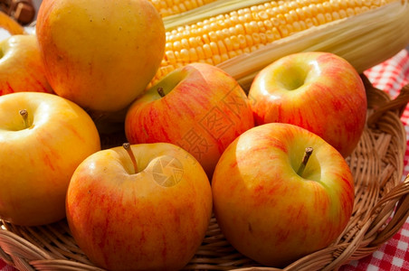 红宝石苹果和玉米椰子在太阳光下的篮子健康黄色秋天高清图片