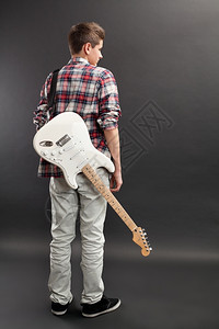 照片上一位十几岁的男站在白色电吉他手的背上超过男人演员图片