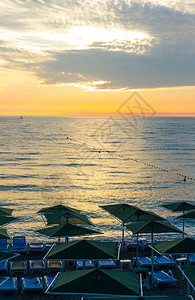 水早晨在土耳其安塔利亚带雨伞和日出的海滩防晒沙床火鸡图片