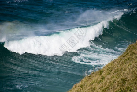 新的海洋浪波即将冲向悬崖图片