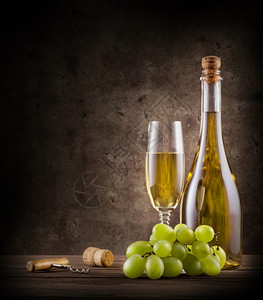 瓶装香槟在木制桌上加葡萄和玻璃瓶装香槟包括葡萄和玻璃液体前景图片