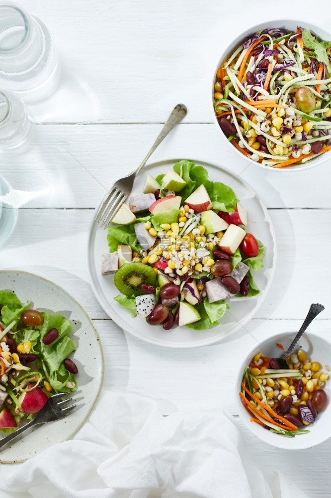 早餐节食美味水果沙拉和白桌上不同水果健康食品概念在白色桌子上素食主义者图片