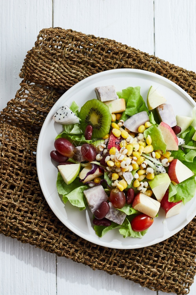 新鲜的吃美味水果沙拉和白桌上不同水果健康食品概念在白色桌子上晚餐图片