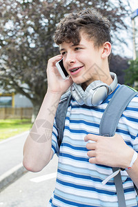 称呼细胞连接的男青少年学生在大外的校关于移动电话的谈图片