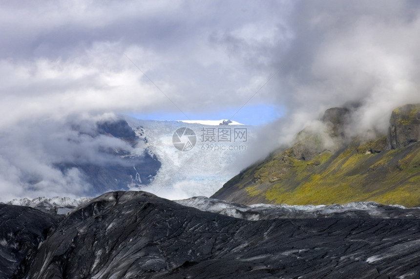污垢黑色的Svinafellsjokull冰川的云层著名冰岛盖之一臂膀Vatnajockull斯维纳菲尔冰川图片