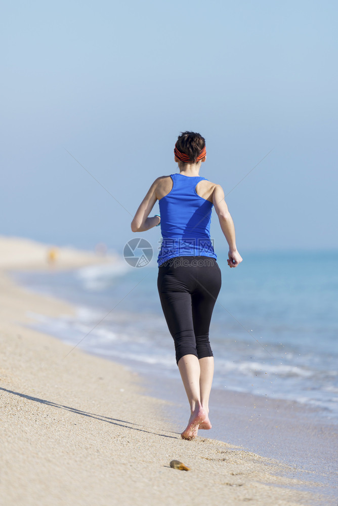 女在海滩上锻炼微笑目的地成人图片