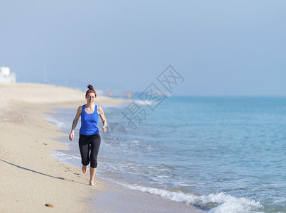 跑步海岸线浪女在滩上锻炼图片