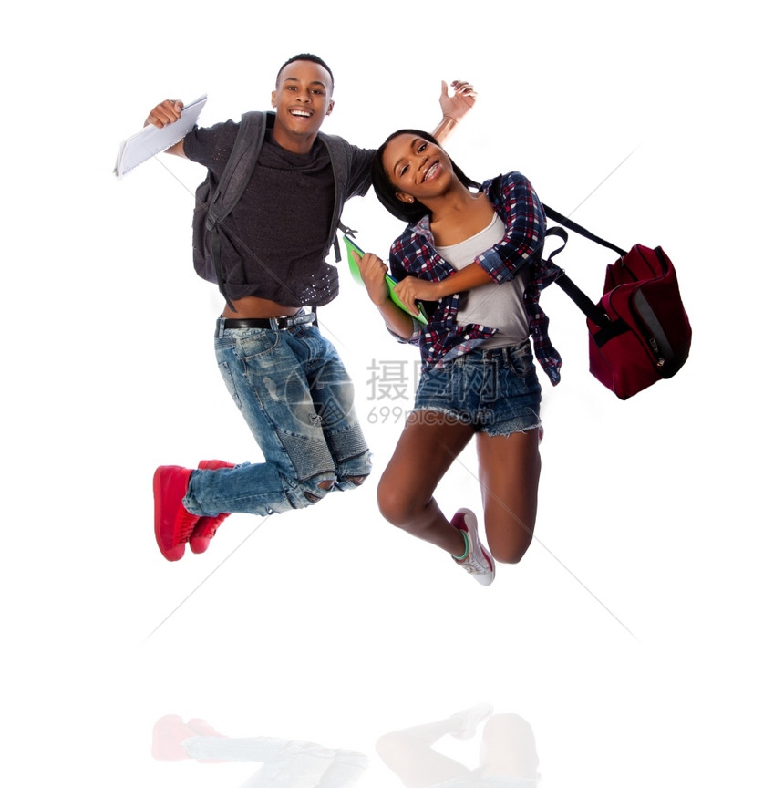 庆祝摄影女孩两个快乐学生跳跃欢庆快乐的带着笔记本和袋子在白色上图片