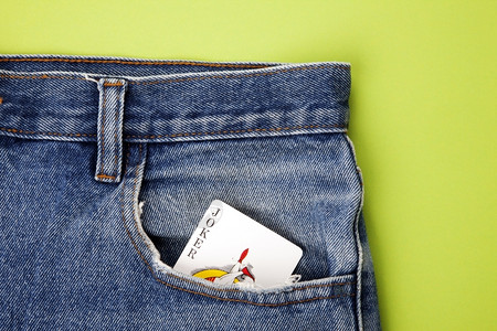 游戏卡牌边框裤子绿色背景蓝牛仔裤口袋的小丑牌游戏卡空白的优质背景