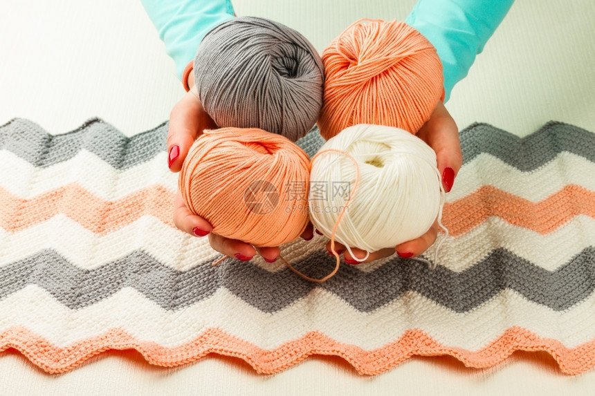 编织波手工制作的柔软编织女手放在白色背景上纺织品图片