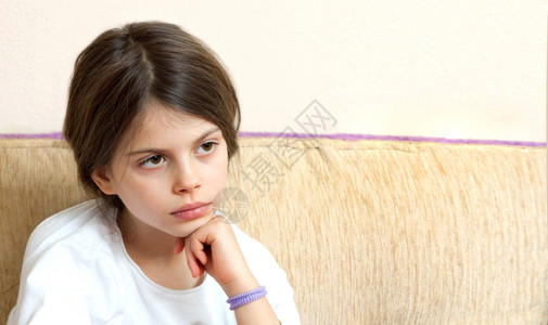 冷漠无聊的家悲哀女孩错过了坐在沙发上彩色照片图片