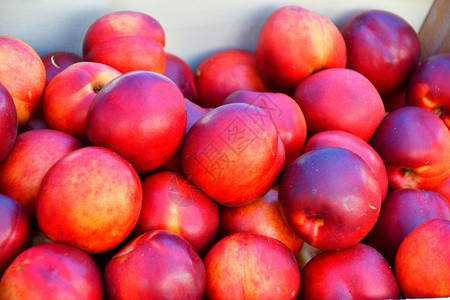 红色桃子市场上出售的新鲜油桃背景