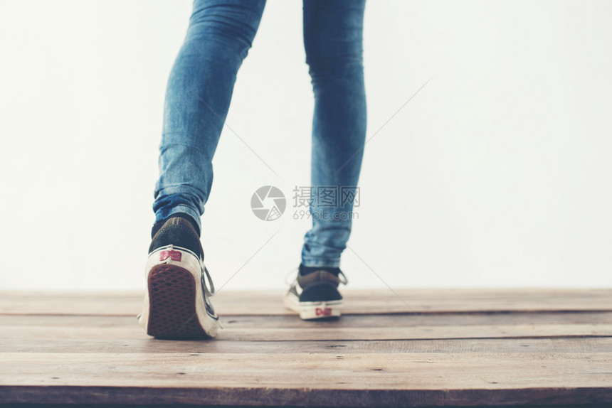 穿蓝色的时髦酷女人脚搭配黑色运动鞋柔软复古色调时髦酷女人脚搭配黑色运动鞋柔和复古色调凉爽的图片