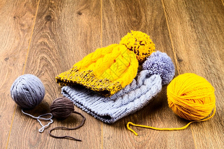 改版上线纺织品温暖的木背景上线和编织帽圆球羊毛背景
