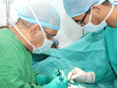 在手术室治疗病人的外科医生图片