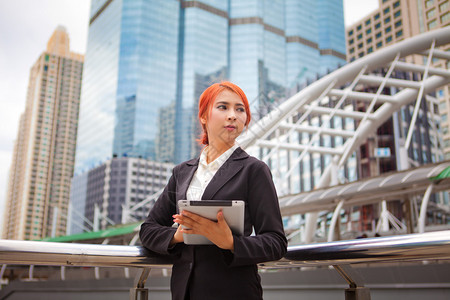 现代城市拥有平板石的年轻商业女天电脑建造图片