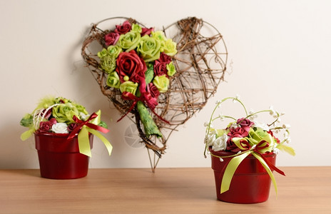 室内装饰带柳条心的装饰套和带玫瑰的红色花盆盛开季节内部的图片