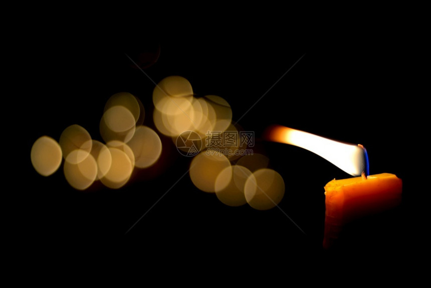 有创造力的戳夜里一朵蜡烛火和bokeh散景图片