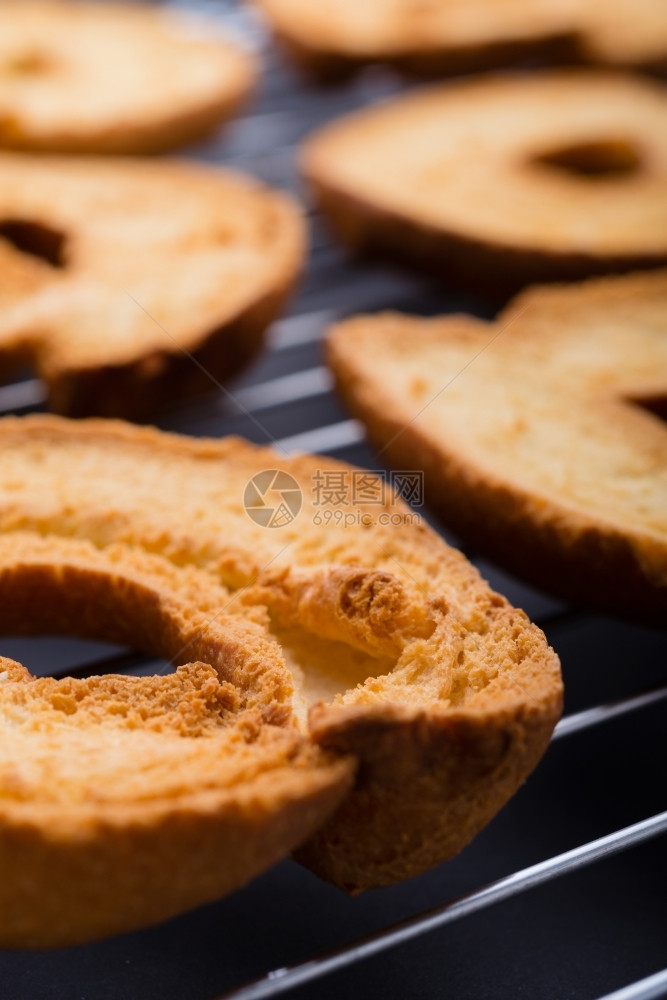 健康戒指烤面包和店在烧烤特近镜头底黑桌表面的烤包和店酥脆图片