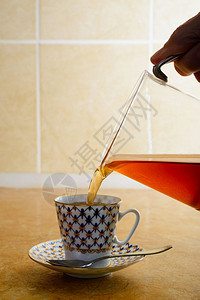 恩格拉纳热热的在厨房把咖啡泡在一个优雅的瓷杯子里瓜拉纳皮背景