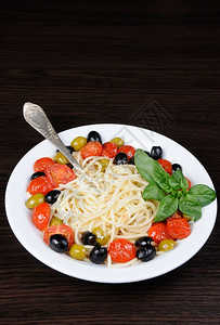 晚餐搅拌糖类含橄榄樱桃西红柿泼洒帕米桑和巴西尔的意大利面图片