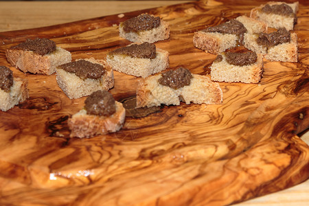 意大利草纸木制板上含肉食的灰色面包切片拉古食物脆的图片