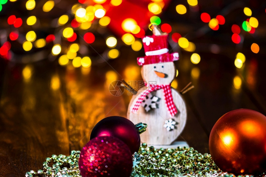 在模糊的灯光背景上被隔绝的多彩圣诞装饰品和中的和闪亮的卡片抽象图片