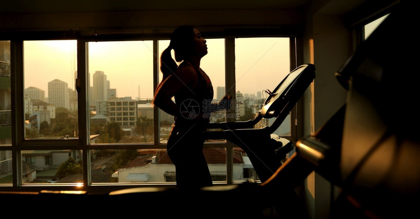 年轻的亚洲女子在运动场上锻炼一种在室内的图片