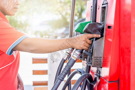 红色的柴油机女雇员正在取油罐车的燃料而女雇员正在取油罐车的燃料活力图片