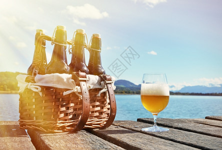 在木制码头对着湖边的啤酒一种厂饮料图片
