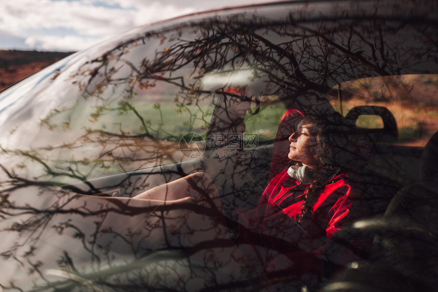 避难所千禧一代年轻妇女在田地下雨时躲一辆汽车内避难放松图片