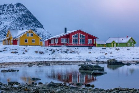 cottage海挪威多色小屋位于冬季晚峡湾边的山顶上冬季傍晚在Fjord和挪威Cottage两地低潮下村庄强盗背景