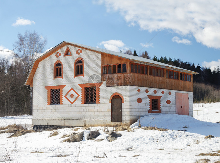 白色的在森林边缘白砖小屋雪覆盖面积春初雪堆阁楼图片