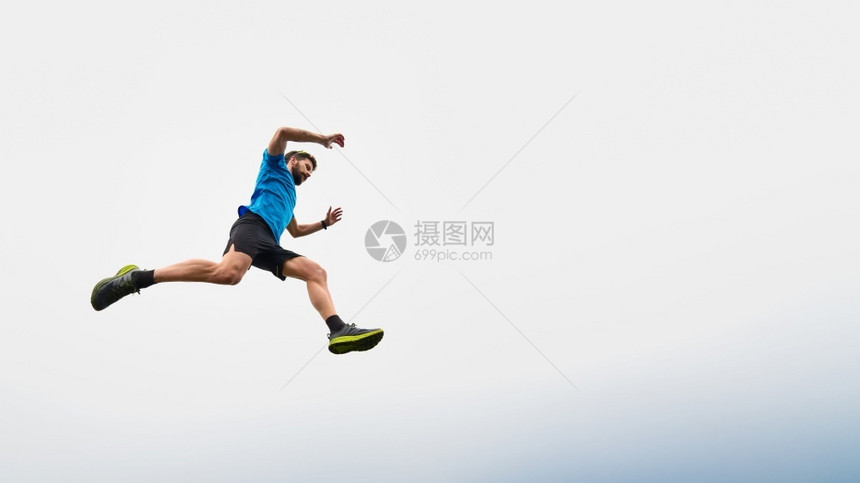远足马拉松运动员在高山上奔跑跳跃天空图片