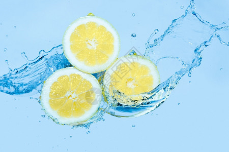 柠檬一种运动一种在浅蓝色背景下在柠檬片上泼水移动背景
