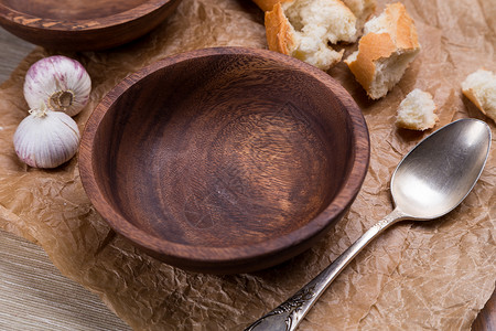 空的法国面包目压碎棕纸上汤空木碗高清图片